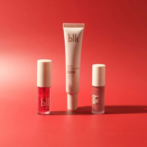 High-end skincare and makeup products elegantly displayed against a vibrant red backdrop.